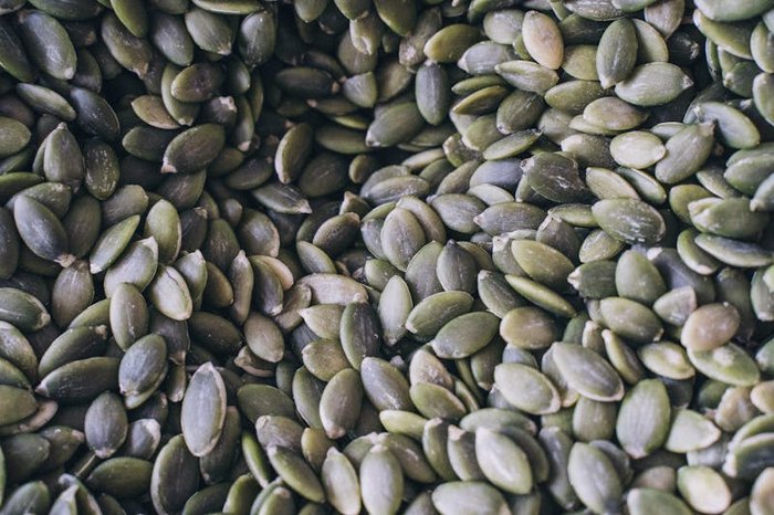 Magnesium-rich foods including pumpkin seeds, almonds, and dark chocolate on a wooden surface